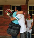 Professora Eva Campos recebe as flores dos alunos Judivan e Alice.