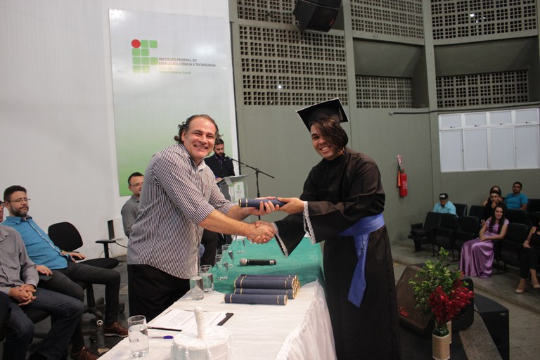 Estudante João Victor recebe diploma das mãos do coordenador 